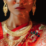 Portrait of Hindu bride in traditional red sari with golden accessories